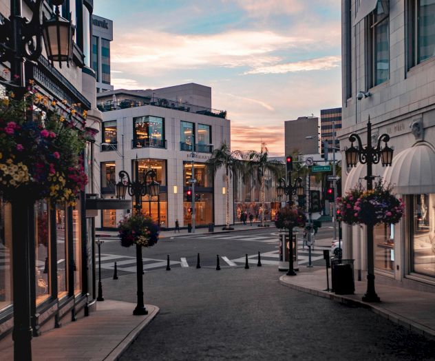 A picturesque street scene at sunset with charming buildings, hanging flower baskets, and a serene atmosphere.